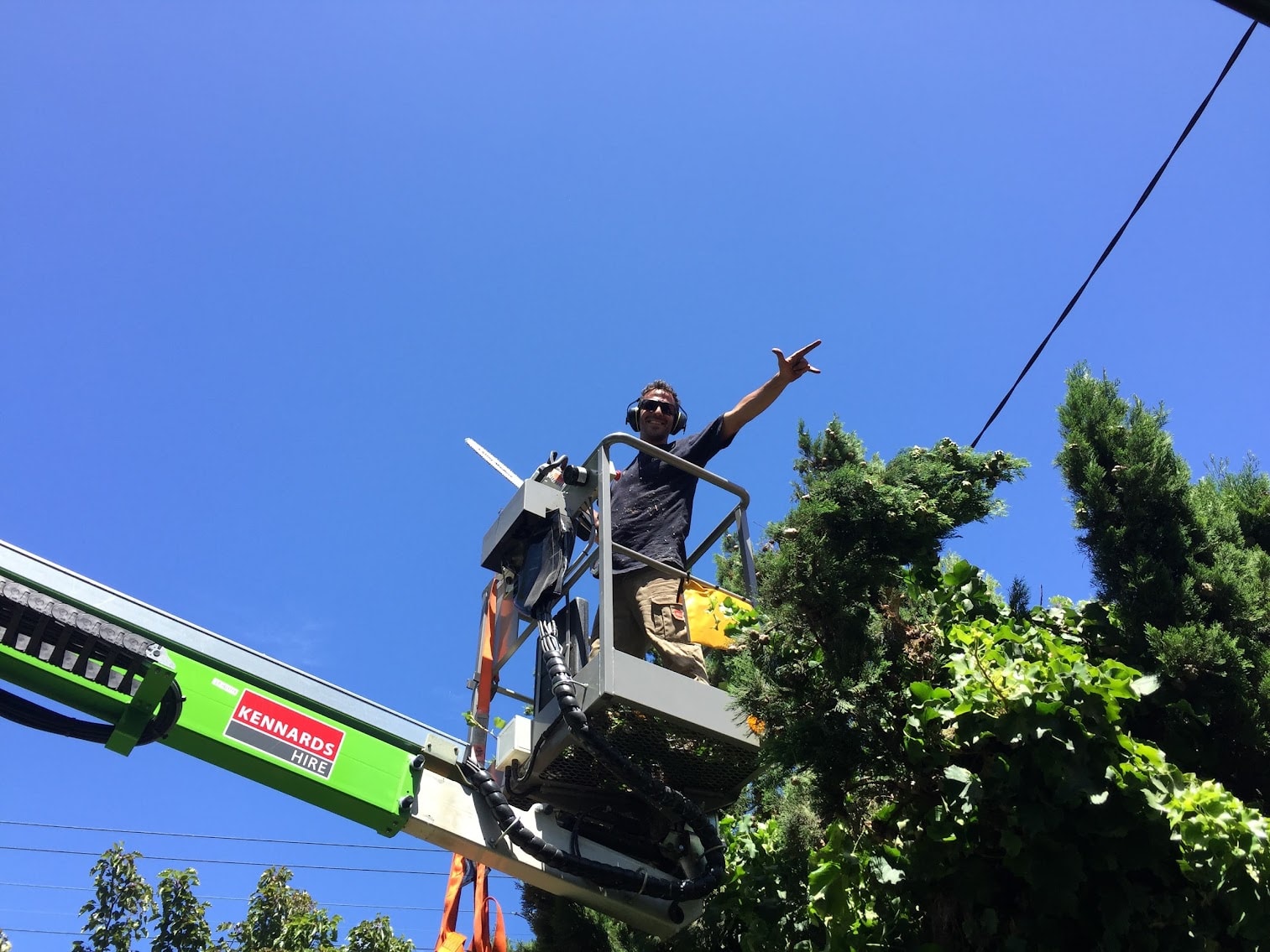Owner on a cherry picker performing tree work in Melbourne